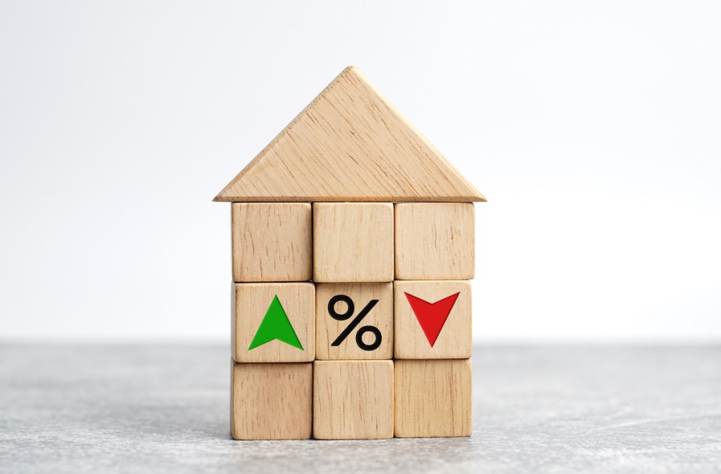 Interest rate financial and mortgage rates concept. house and real estate. Wooden cube block with icon percentage, symbol arrow up and down.